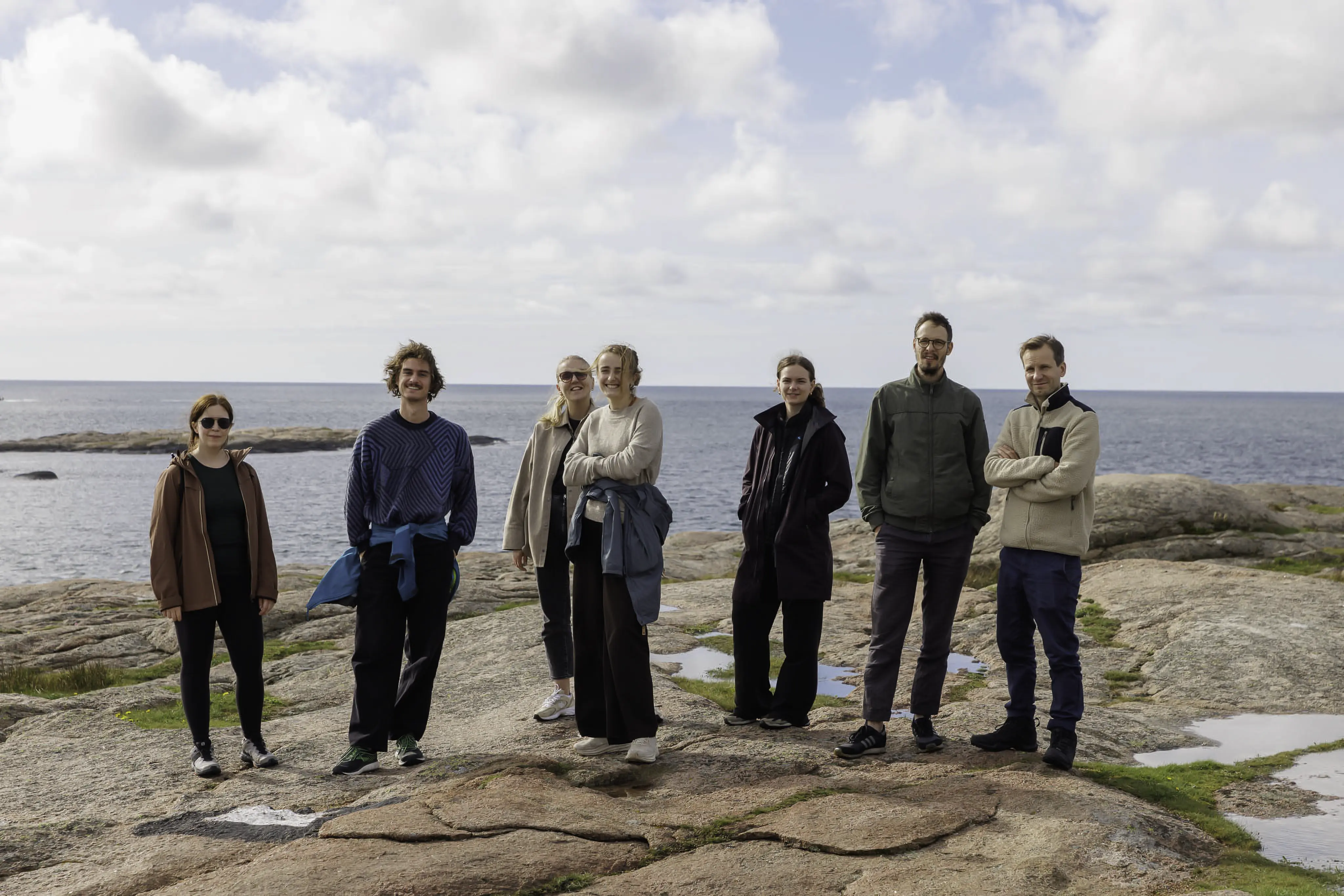 Glade folk ute på et skjær i naturen