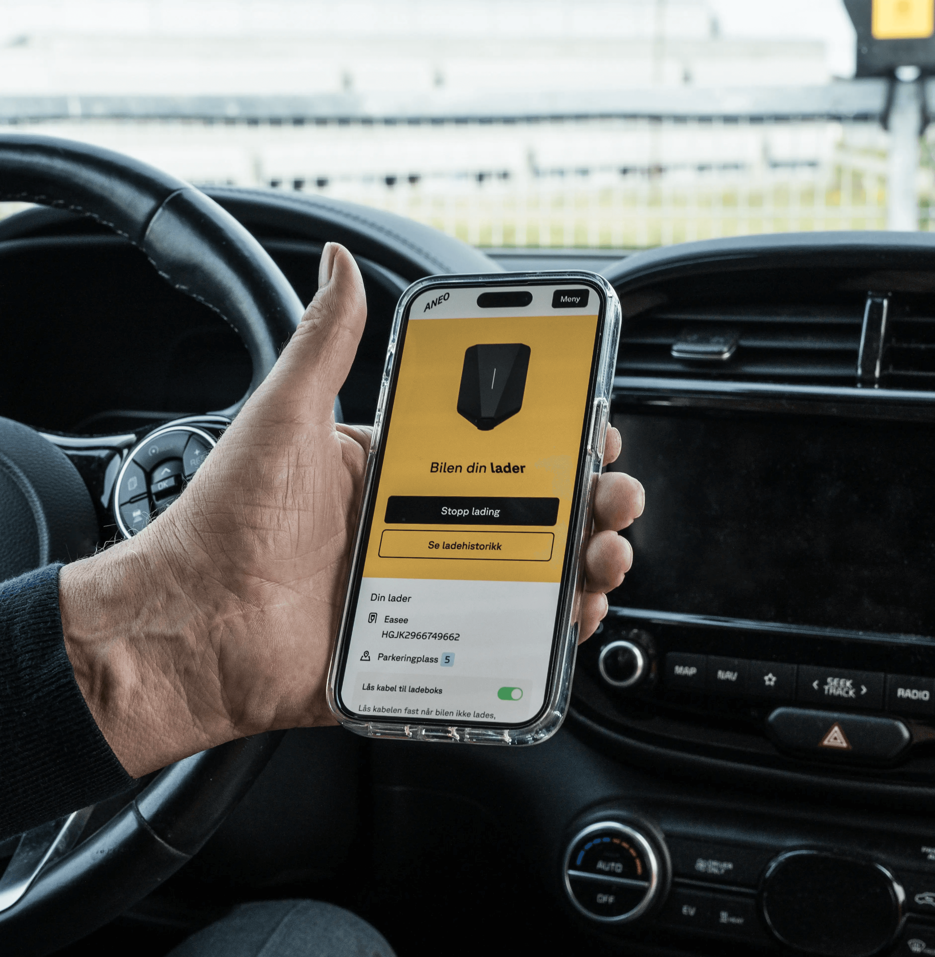 Hånd som holder telefon med Aneo appen